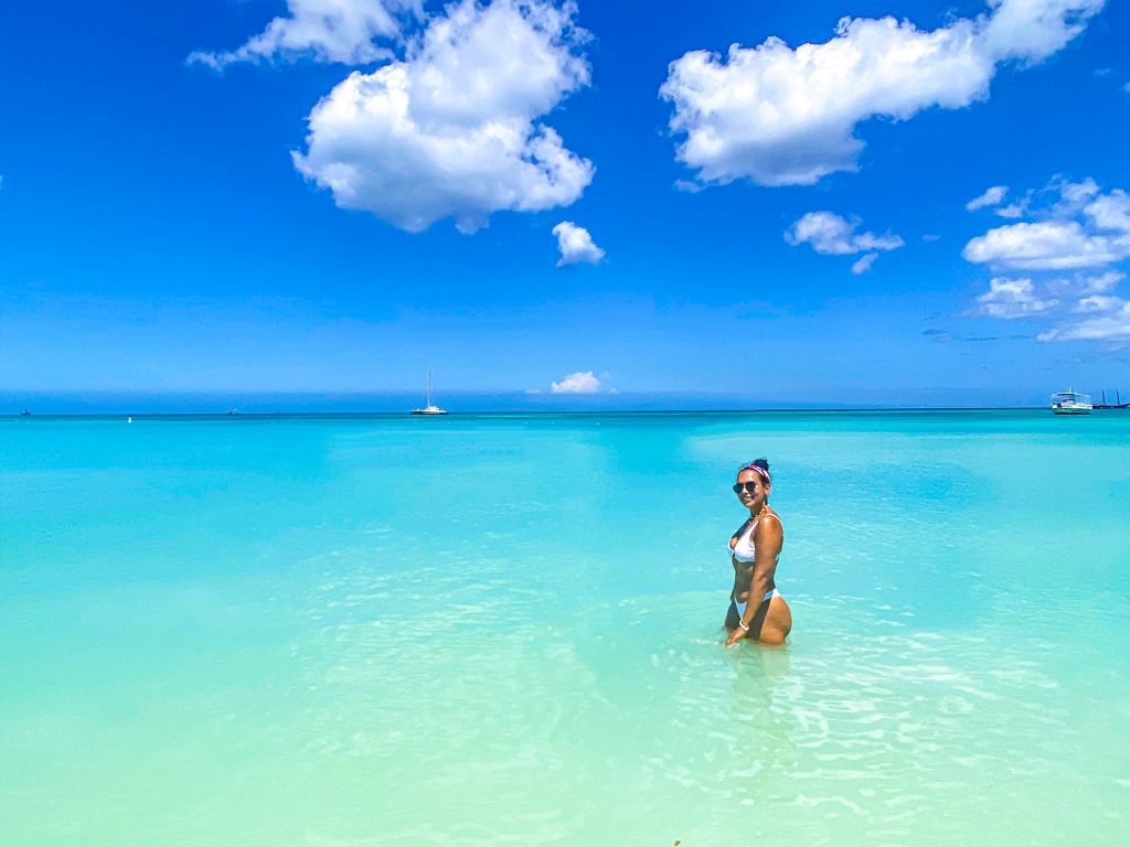 Foto da Camilli, com biquíni branco dentro do mar na praia de Palm Beach