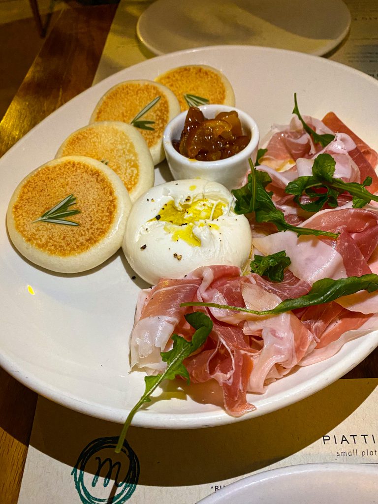 Foto de um prato com pãozinho, burrata e presunto cru no post sobre onde e o que comer em Chicago