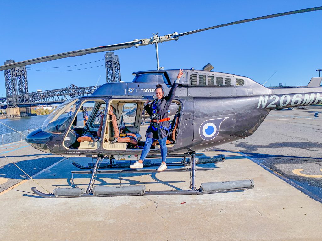 Foto da Camilli em pé no helicóptero da FLYNYON