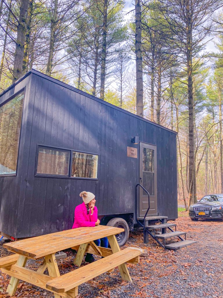 Foto da Camilli usando casaco rosa do lado de fora da cabine em Catskills